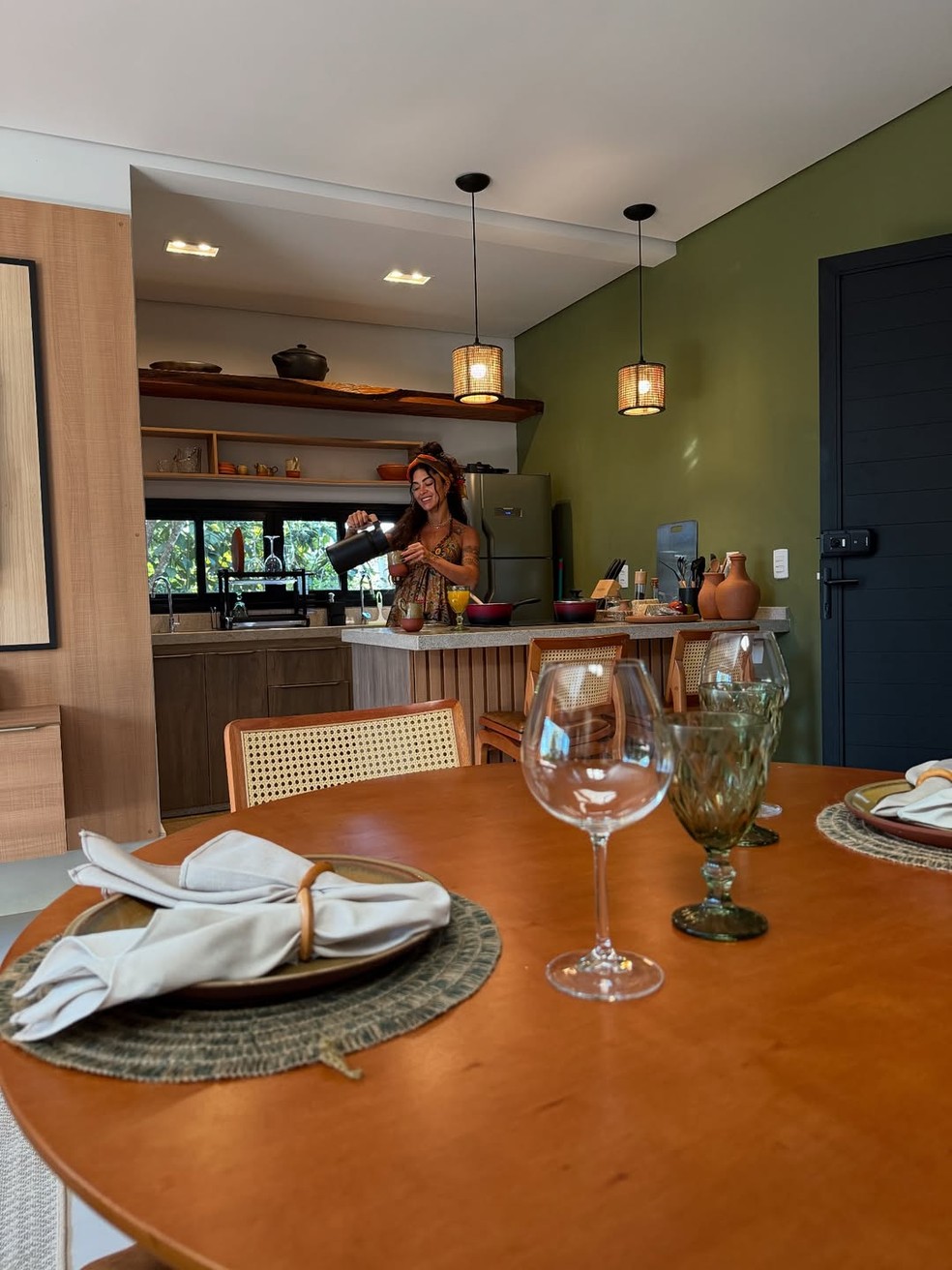 Aline Campos na cozinha da hospedagem, que é integrada com a sala — Foto: Instagram/Reprodução