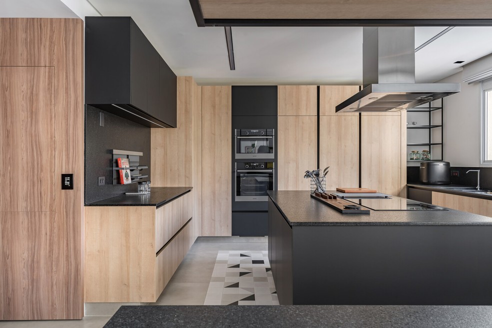 COZINHA | A combinação entre preto e madeira cria um ambiente sóbrio e jovial na cozinha — Foto: Kadu Lopes / Divulgação