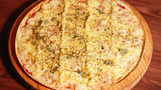 Receita prática de pizza caseira com recheio de quatro queijos; confira!