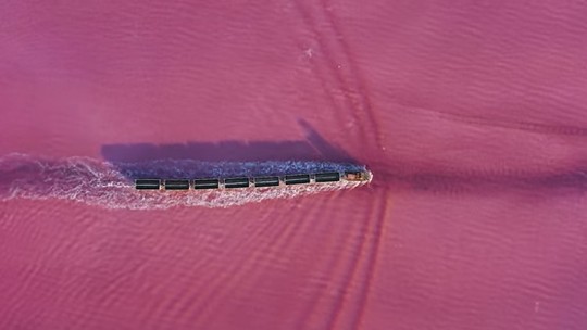 Trem que anda pela água de lago cor-de-rosa atrai turistas até a remota Sibéria