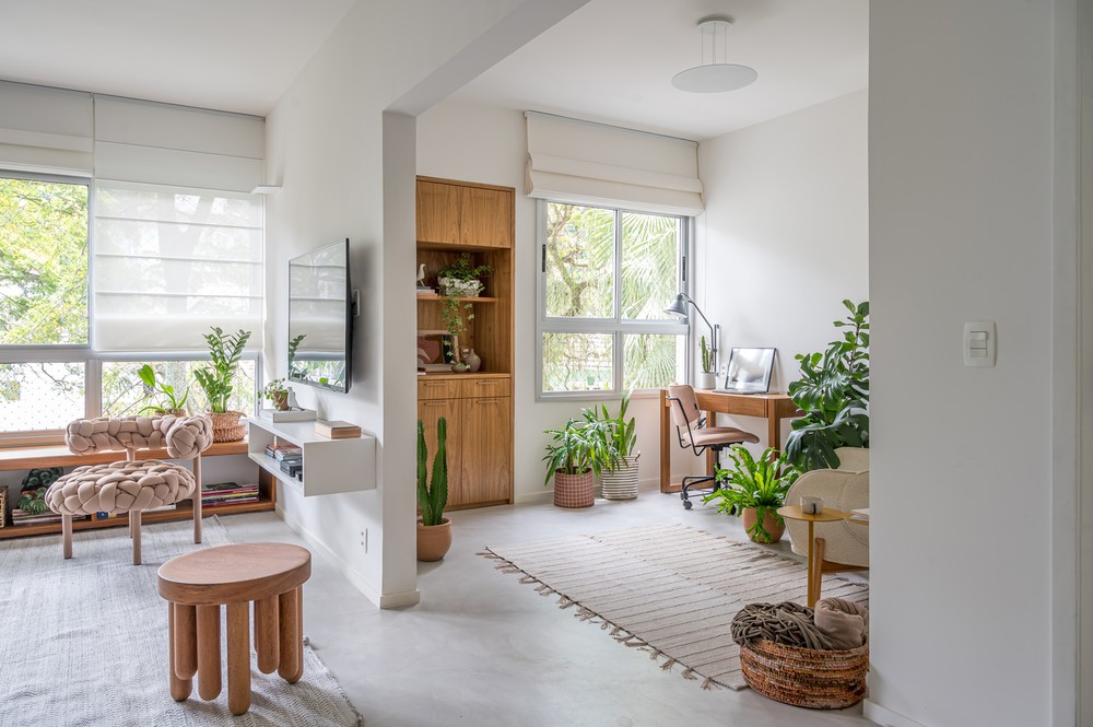 Apartamento com base neutra tem muita madeira e plantas na decoração
