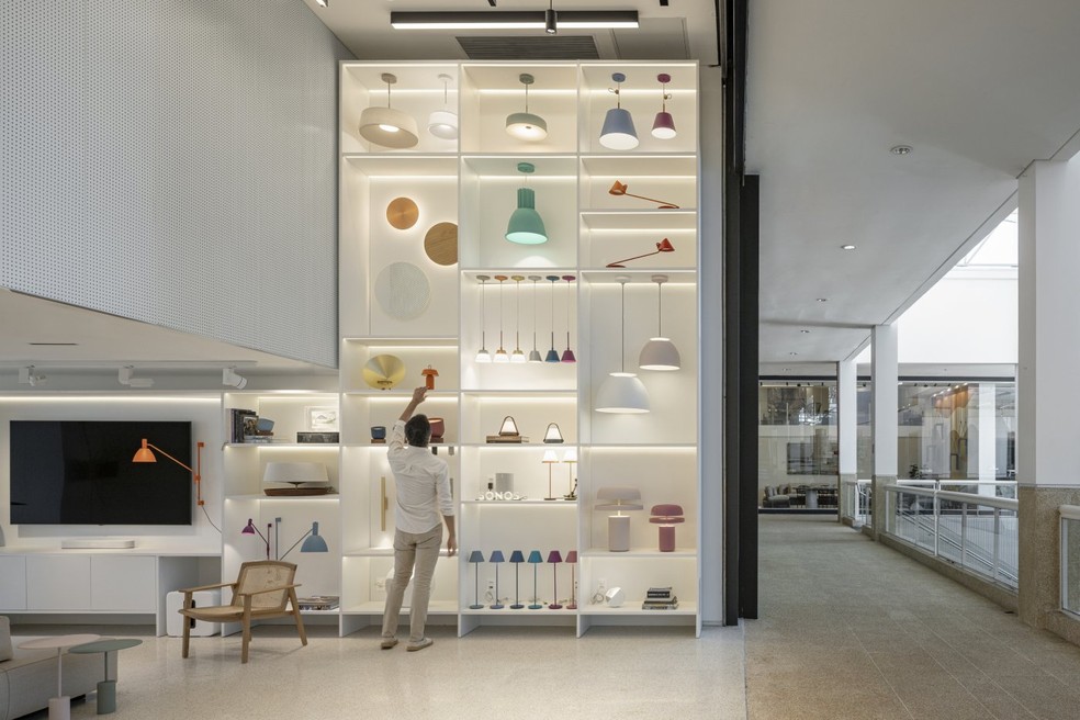 A base branca da loja contrasta com as cores das peças da Lumini, permitindo que os visitantes visualizem os produtos de forma clara — Foto: Joana França / Divulgação