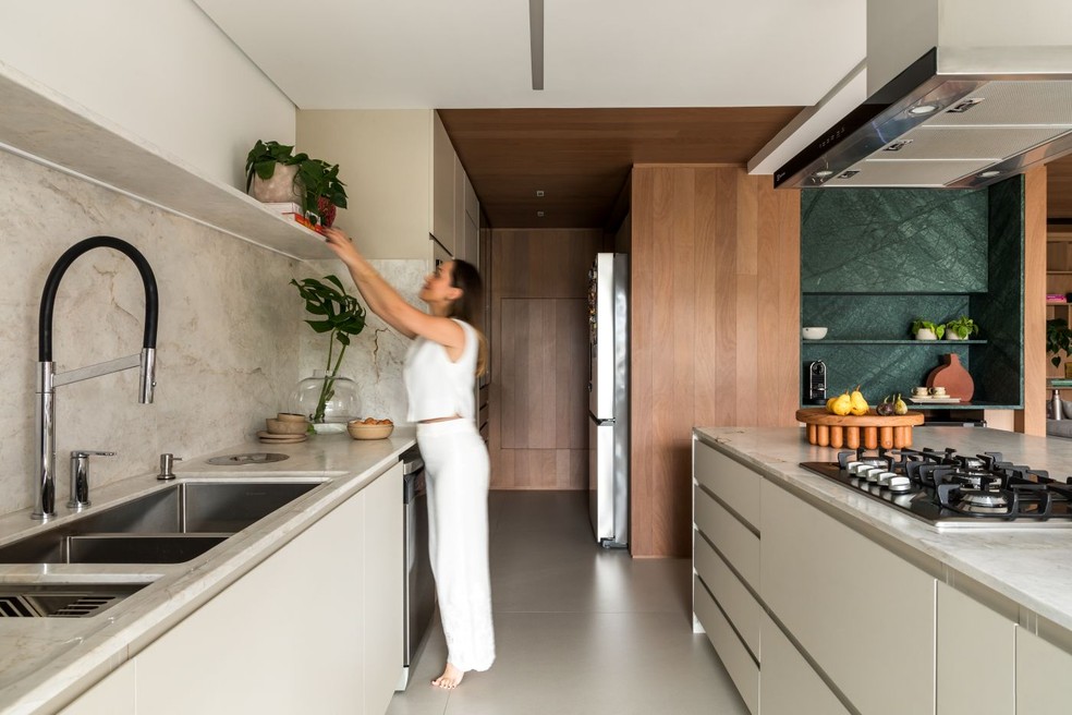 No projeto do escritório Renata Lora de Bem Arquitetura, o mesmo mármore Branco Paraná levigado, da Michelangelo, aplicado na ilha, está na bancada da pia e no frontão — Foto: Eduardo Macarios/Divulgação