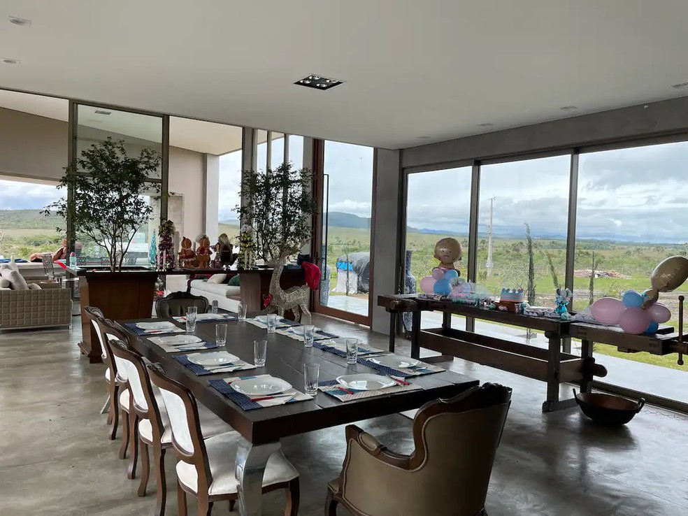 A sala de jantar da casa é espaçosa e tem vista para uma paisagem impressionante — Foto: Airbnb / Reprodução