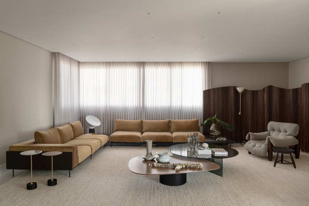 Nesta sala de estar, o generoso sofá de veludo, da América Móveis, compartilha o espaço com peças de design brasileiro — Foto: Estúdio NY18/Divulgação | Projeto do escritório Graziella Nicolai Arquitetura