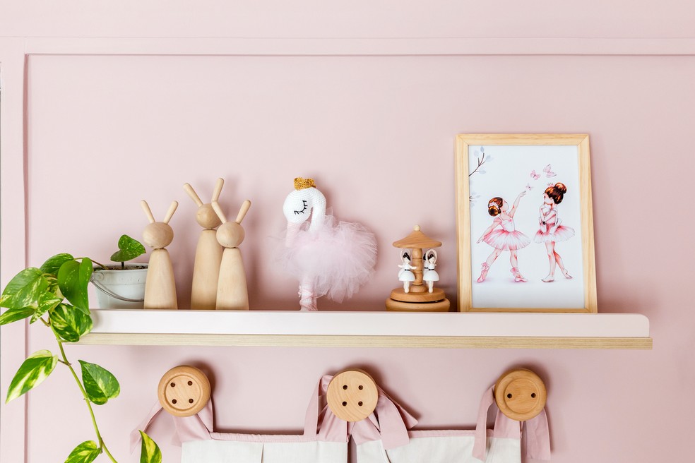 Detalhes que encantam na estante sobre a cômoda. Os objetos de madeira são da Pimbos Kids — Foto: Mariana Lima / Divulgação 