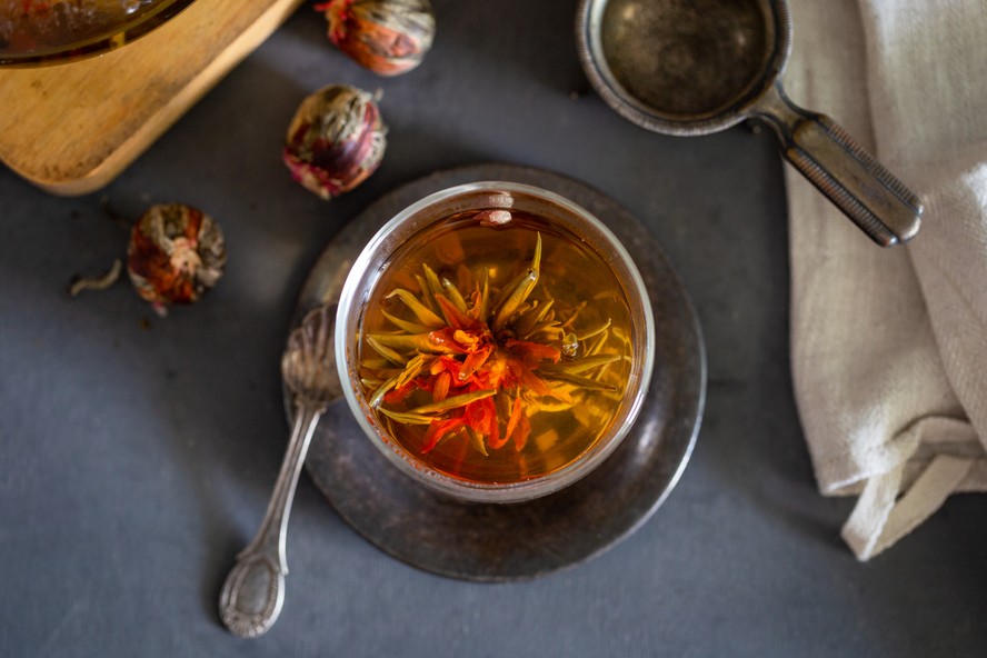 O chá de floração se abre em contato com a água quente, revelando as flores. Food stylist Norma Lima