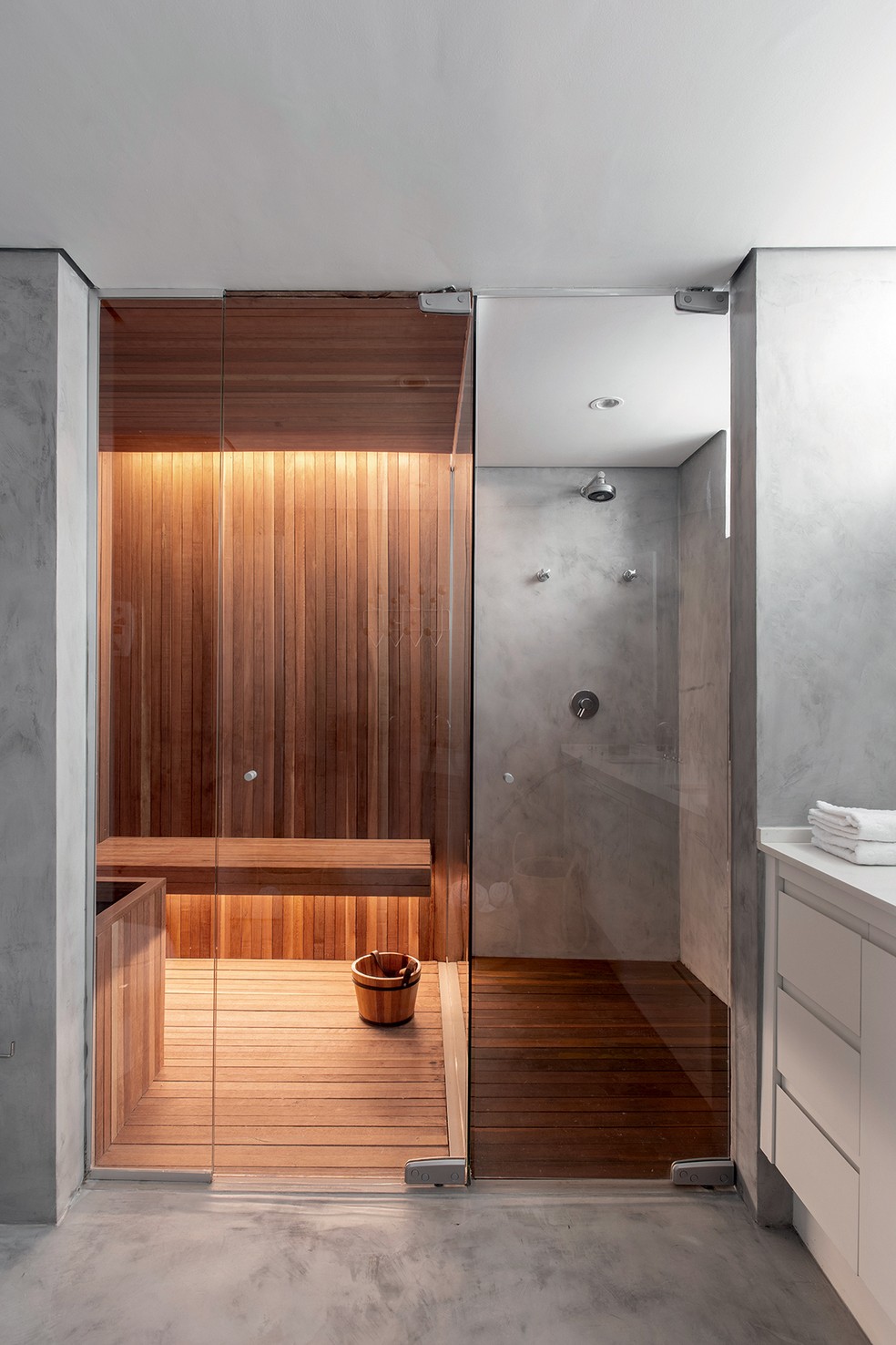 O banheiro ganhou sauna revestida de réguas de eucalipto e boxe da ducha com deque de cumaru da Império das Saunas — Foto: Carolina Lacaz / Divulgação