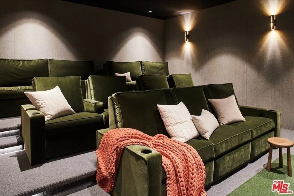 O cinema tem sofás grandes e confortáveis na cor verde — Foto: Realtor.com / Reprodução