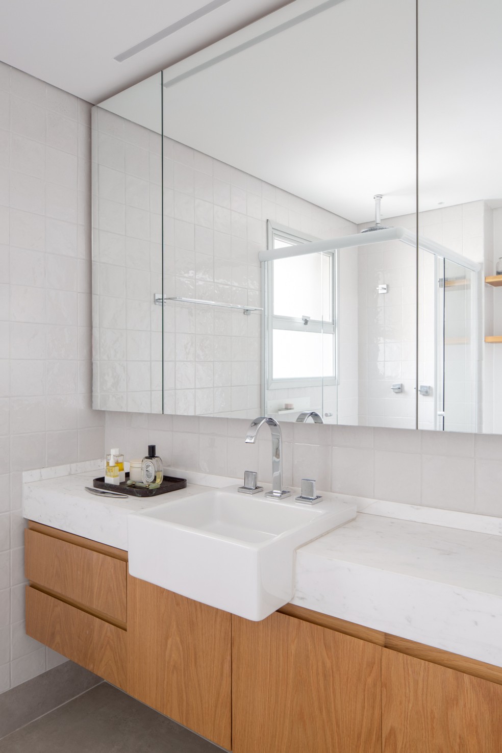 BANHEIRO | O revestimento do banheiro é da Colormix. O espelho tem portas de armário nas duas pontas, solução que ajudou a moradora, pois ela tem muitos produtos de beleza — Foto: Carolina Lacaz / Divulgação