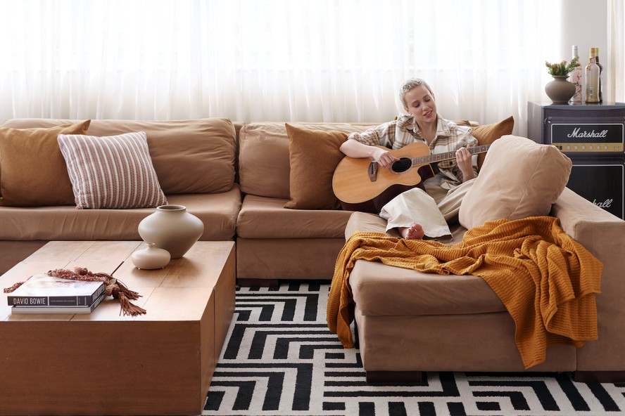 LIVING | Marcella Rica toca violão no agradável living de seu apartamento na Barra da Tijuca, no Rio de Janeiro