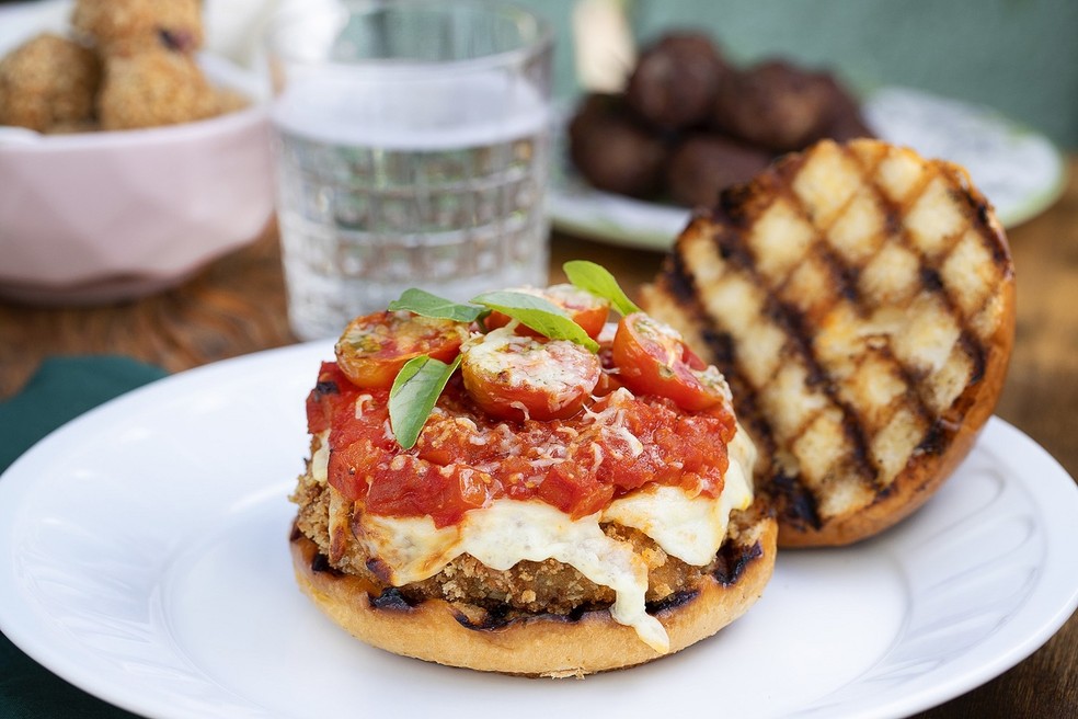 A receita de hambúrguer à parmegiana tem um toque especial com tomates cereja, parmesão e manjericão — Foto: Izzimo / Divulgação