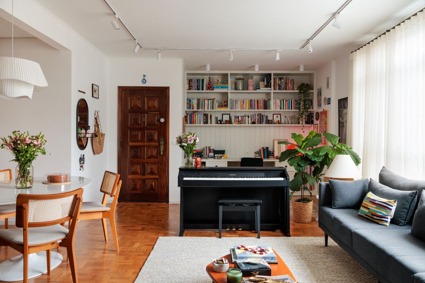 Apartamento em SP reúne arte, música, piso de taco e cozinha azul para receber