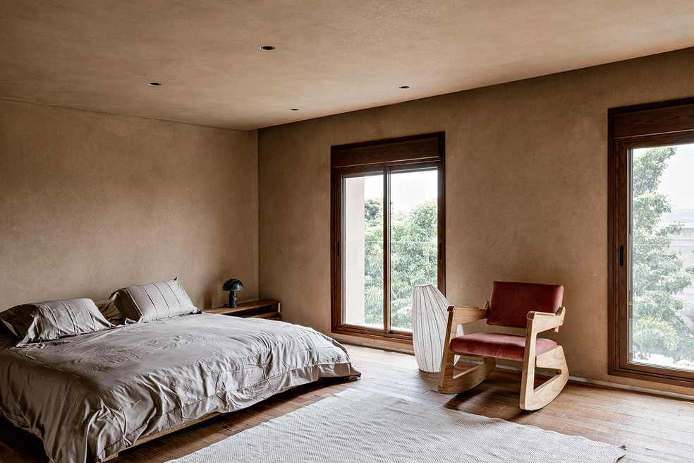 QUARTO | O quarto da suíte máster tem caixilho igual nas janelas com vidro de correr e venezianas rolô de madeira. Teto e paredes têm a mesma pintura. Cama e mesa de cabeceira da Casa Atica. Poltrona da Etel — Foto: Fran Parente / Divulgação