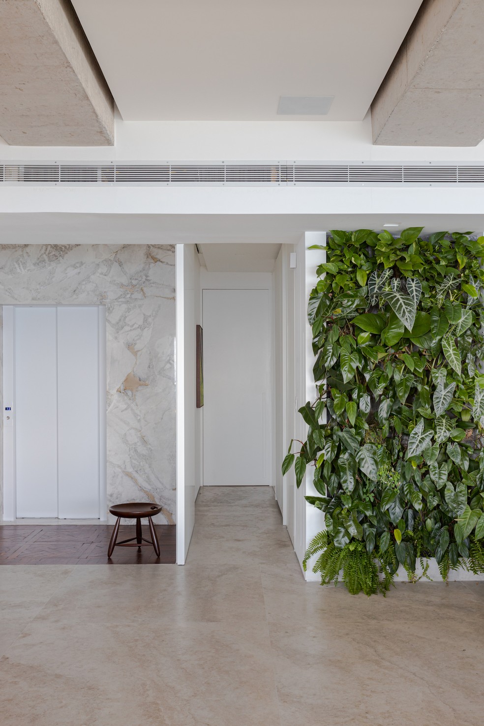 HALL | O pé-direito alto e o uso de muitas plantas conferem a atmosfera desejada de uma casa — Foto: Gabriela Daltro / Divulgação
