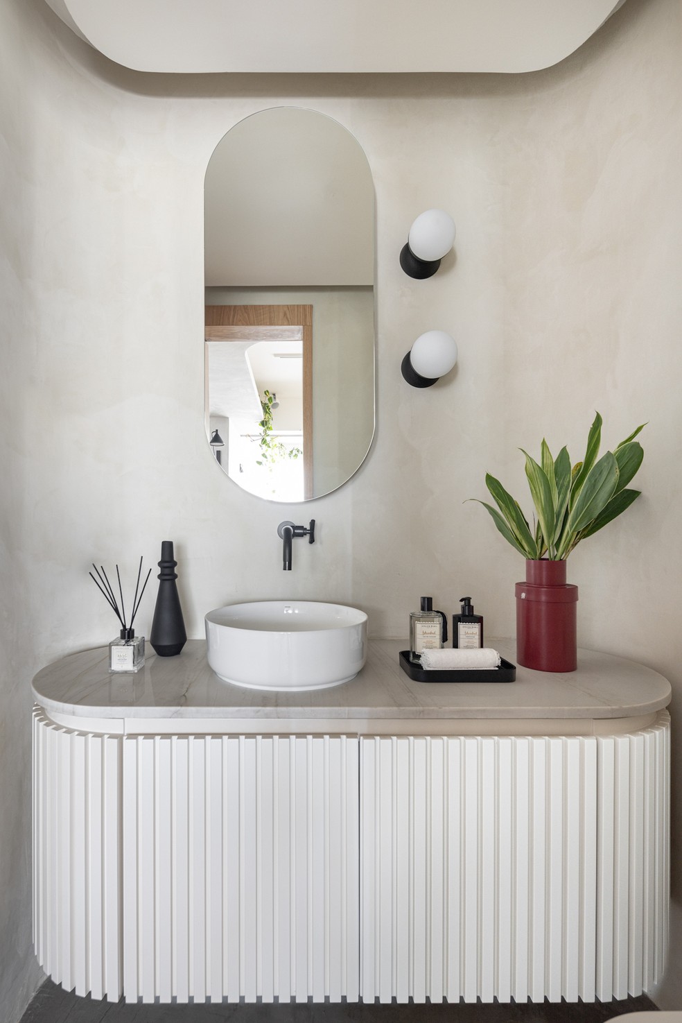 LAVABO | Majoritariamente branco, o lavabo tem uma atmosfera mais clássica. Vaso da Selvvva — Foto: Joana França / Divulgação | Produção: Mayra Navarro