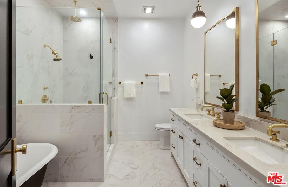 O banheiro luxuoso da suíte tem banheira e pias duplas — Foto: Mls.com / Carolwood Estates / Reprodução