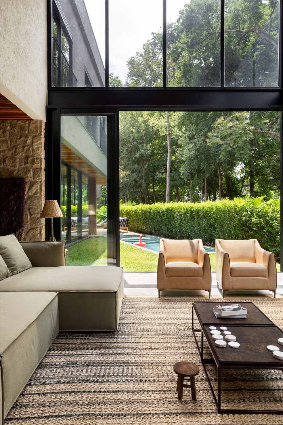 SALA DE ESTAR | Com abertura para o jardim com piscina, a sala comporta o sofá cinza Pillow, do estudiobola — Foto: Keniche Santos/Divulgação