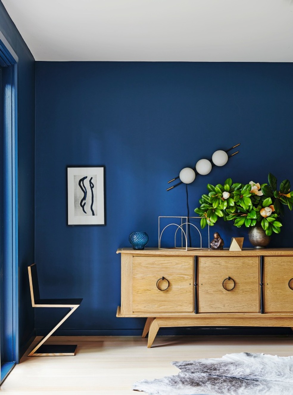Neste projeto da designer de interiores Belinda Hall, o aparador da década de 1950 contrasta com o azul das paredes — Foto: Lisa Cohen / Living Inside / Divulgação