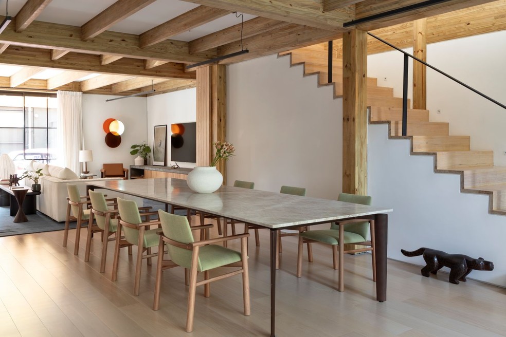 SALA DE JANTAR | A estrutura aparente de madeira da Rewood continua na escada, ao lado da mesa de linhas leves e as cadeiras da Ovo. Piso da Parket. Objetos da dpot. Iluminação da Reka — Foto: Ruy Teixeira/Divulgação