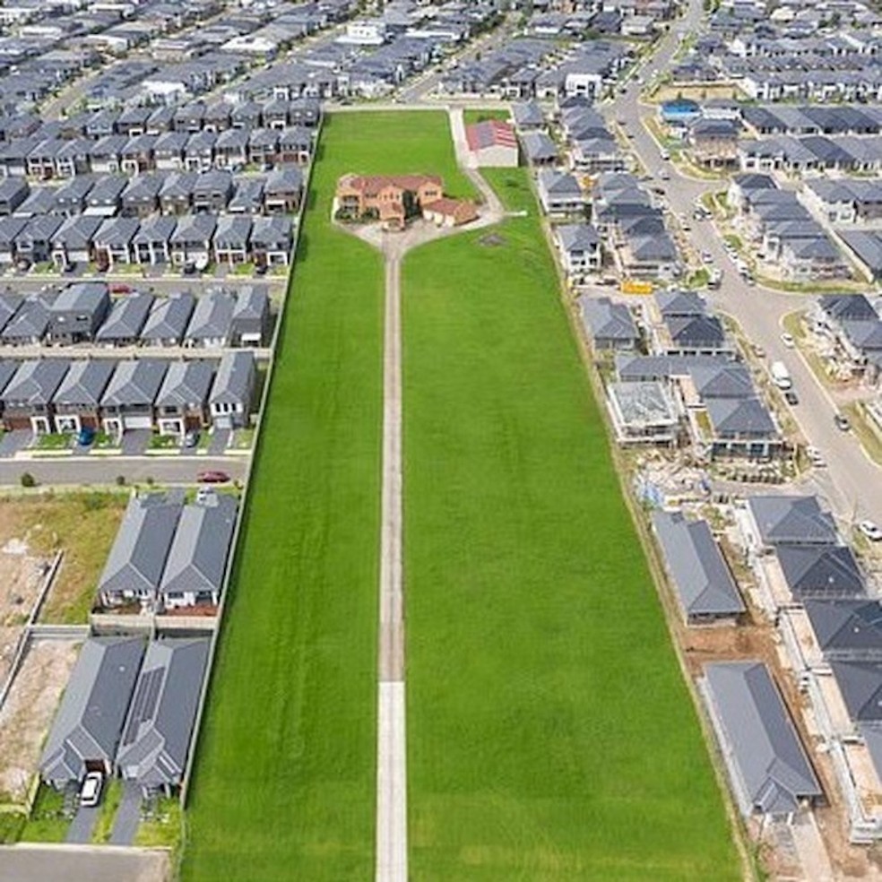 A ampla área verde contrasta com o mar de casas de telhado cinza ao redor — Foto: Instagram / @jerryscience / Reprodução