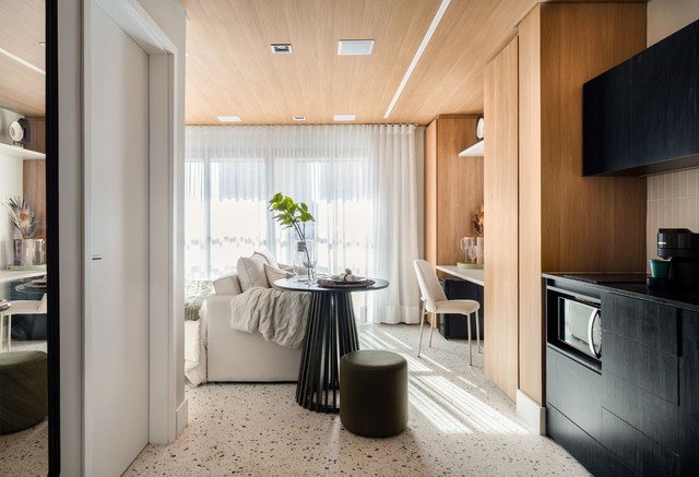 Madeira e granilite conferem aconchego e unidade visual a apê de 25 m²