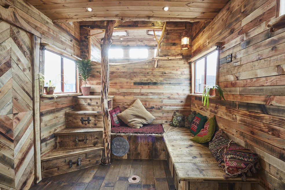 Um mezanino na parte superior da casa em um caminhão de cavalos serve como quarto de casal — Foto: House Box / Reprodução