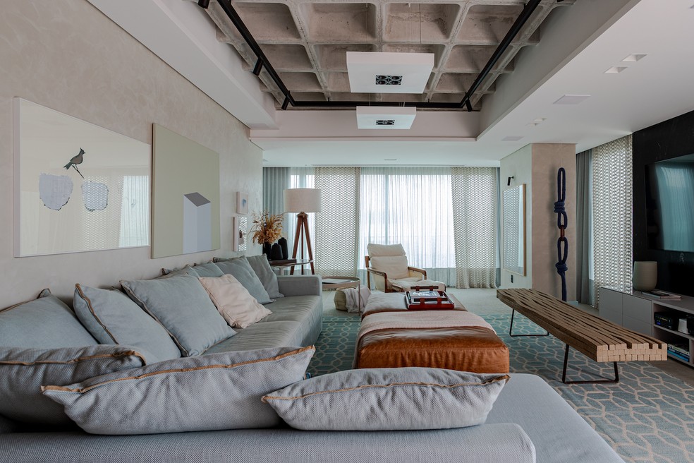 LIVING | O amplo e confortável sofá azul claro é um dos grandes destaques. Tapete da ByKamy, móveis soltos da Studio Ambientes e itens decorativos da Roka Ideias e Objetos — Foto: Gabriela Daltro / Divulgação