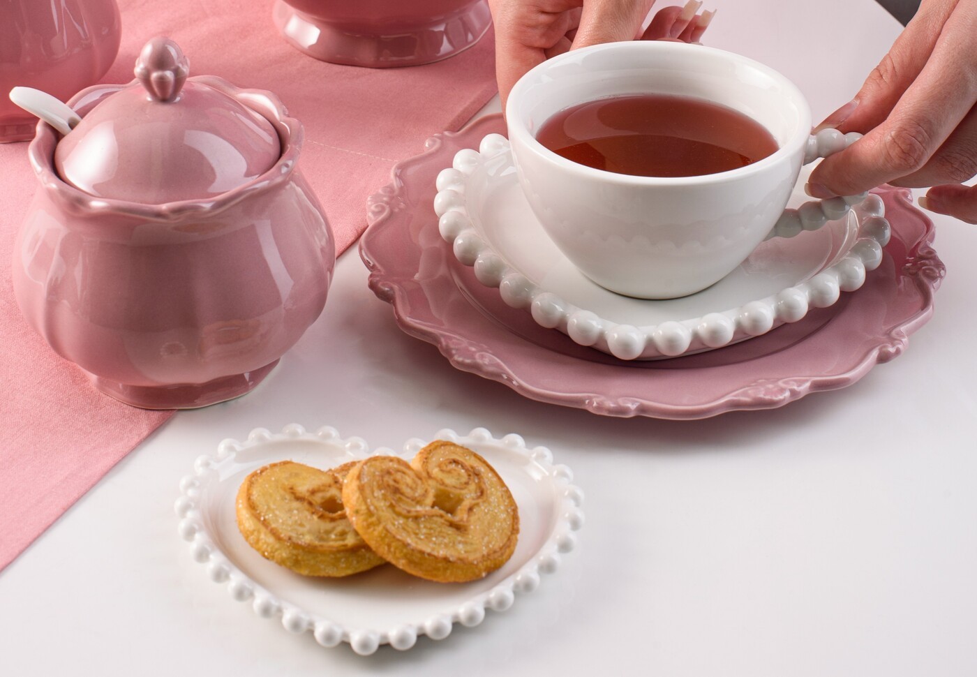 O conjunto de quatro xícaras de chá com pires coração (R$ 166,20) e o prato de sobremesa rose (R$ 41,40), ambos da Woly, são peças de porcelana, que adicionam criatividade à mesa, sem deixar a delicadeza de lado — Foto: Woly / Divulgação