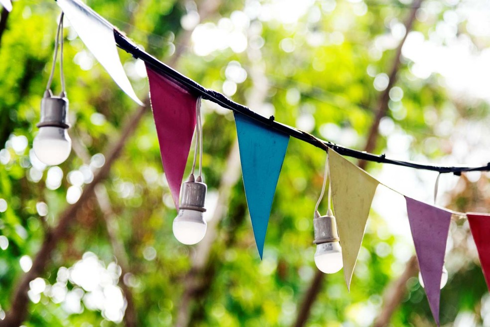 Entre os detalhes da decoração de uma festa em casa, bandeirinhas e luzes podem dar cor e brilho no visual — Foto: Freepik / rawpixel / Creative Commons