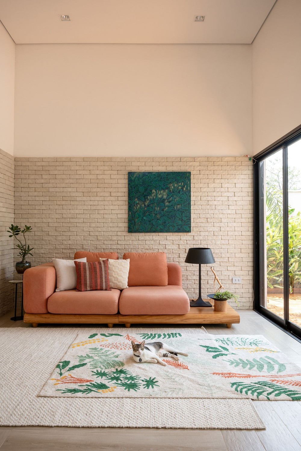 Casa minimalista tem pontos de cor e integração com jardim e piscina
