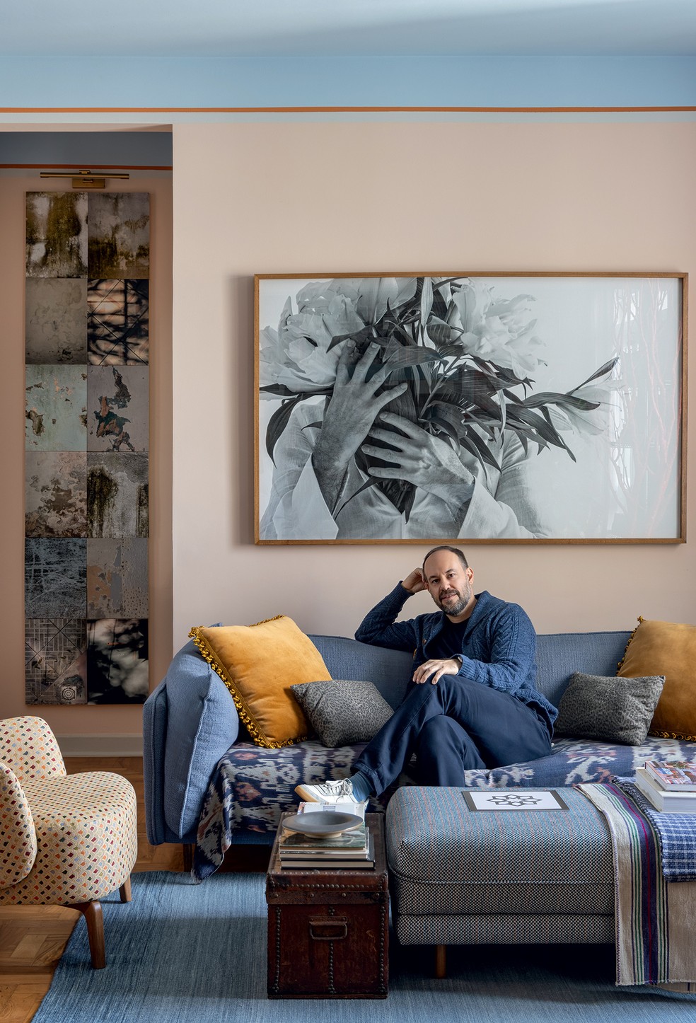 RETRATO | A sala, onde Marcelo Salum senta-se no sofá Vanilla, da Studio Ambientes, mesmo nome e fornecedor do pufe à frente. O baú é da Loja Teo. Na parede, foto de Salvador Cordaro e, à esquerda, obra de Juliana Hoffmann — Foto: Arq.verso/Divulgação