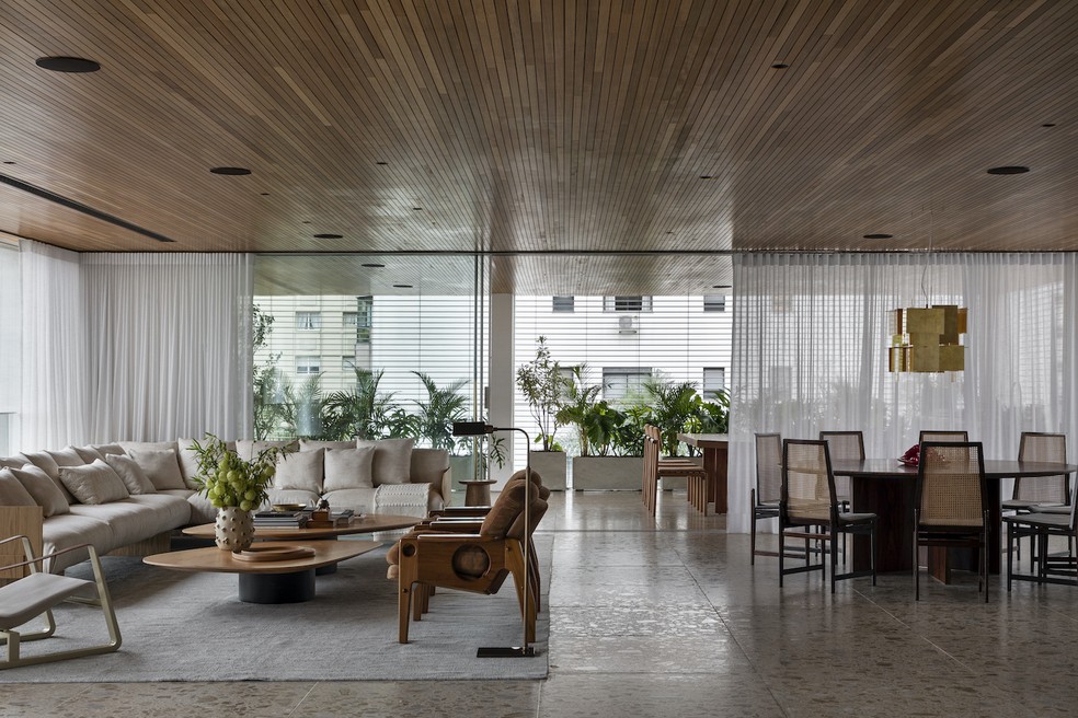 A total integração entre os espaços marca a ala social deste apartamento no Alto de Pinheiro. Mesa de jacarandá do acervo dos moradores. Cadeiras de Jorge Jabour Mauad, da Móveis Cantú. Pendente "1000 Karat Blau", de Axel Schmid para a FAS. Sofá "Box", de Jader Almeida. Poltronas "Renata", de Sergio Rodrigues. Mesa de centro Blast, da Micasa. Tapete da Botteh. Iluminação técnica da Mingrone Iluminação. Projeto da arquiteta Melina Romano — Foto: Denílson Machado/Divulgação