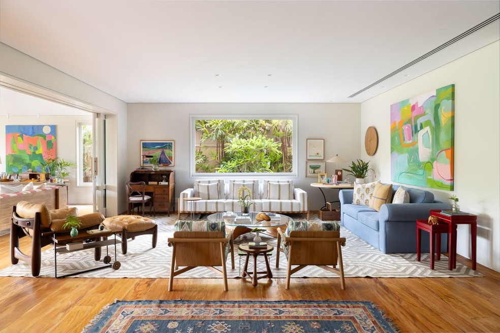 Sob a janela, sofá Vittorio, de Isabelle De Mari, que também assina o par de poltronas Tokyo, na Olho Móveis, as quais foram revestidas com tecidos da Calê Home — Foto: Keniche Santos/Divulgação | Projeto do escritório Cacau Ribeiro Interiores