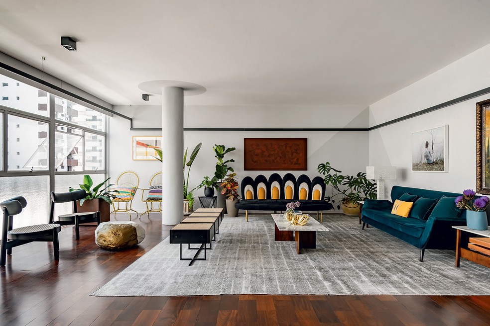 O sofá revestido de veludo azul, à direita, é do acervo dos moradores. Ao fundo, o sofá Margarida, desenhado pelo escritório MM18 Arquitetura, garante harmonia na composição — Foto: Wesley Diego/Divulgação | Produção: Tiago Cappi/Divulgação | Projeto da arquiteta Mila Strauss