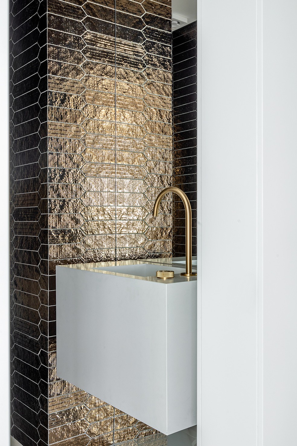 LAVABO | Totalmente revestido com o material cerâmico dourado da Dune, o lavabo tem um ar moderno. Metais da Docol — Foto: Fábio Jr. Severo / Divulgação