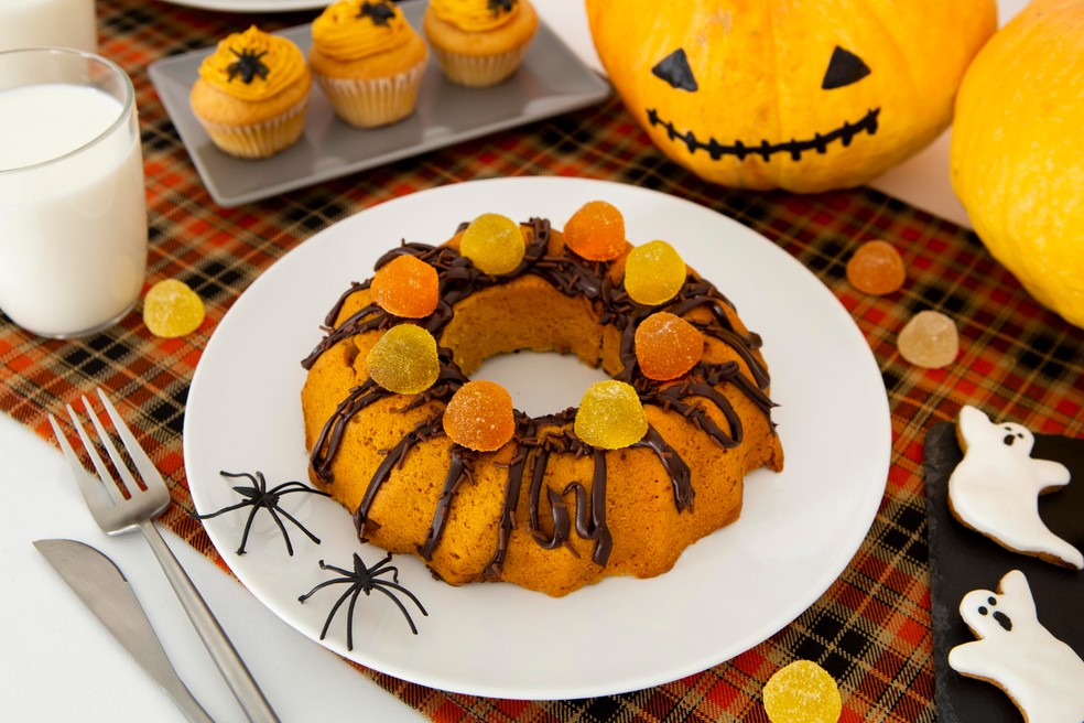 Um bolo temático e jujubas nas cores do Halloween transformam a mesa em um verdadeiro banquete assustador — Foto: Freepik/Creative Commons