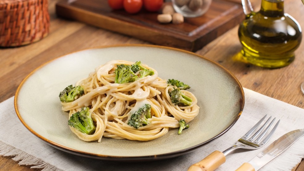 Receita de espaguete com brócolis e molho branco vegano é saudável e fácil — Foto: Selmi / Divulgação